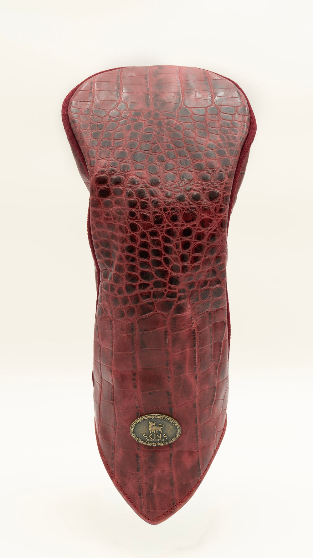 A red crocodile-embossed leather golf club headcover, shown upright against a plain white background. A small oval metal brand badge is attached near the bottom tip.