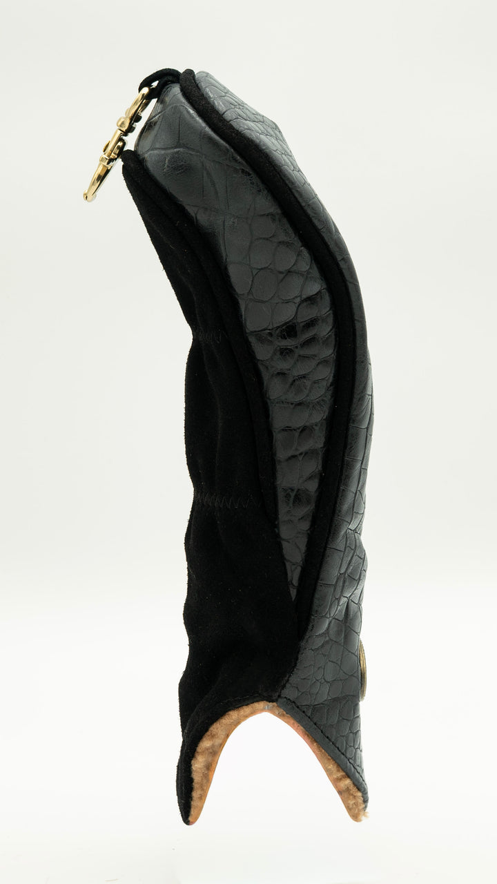 A black textured leather boot cover with a gold-tone zipper and a light tan lining visible at the bottom, shown against a plain white background.