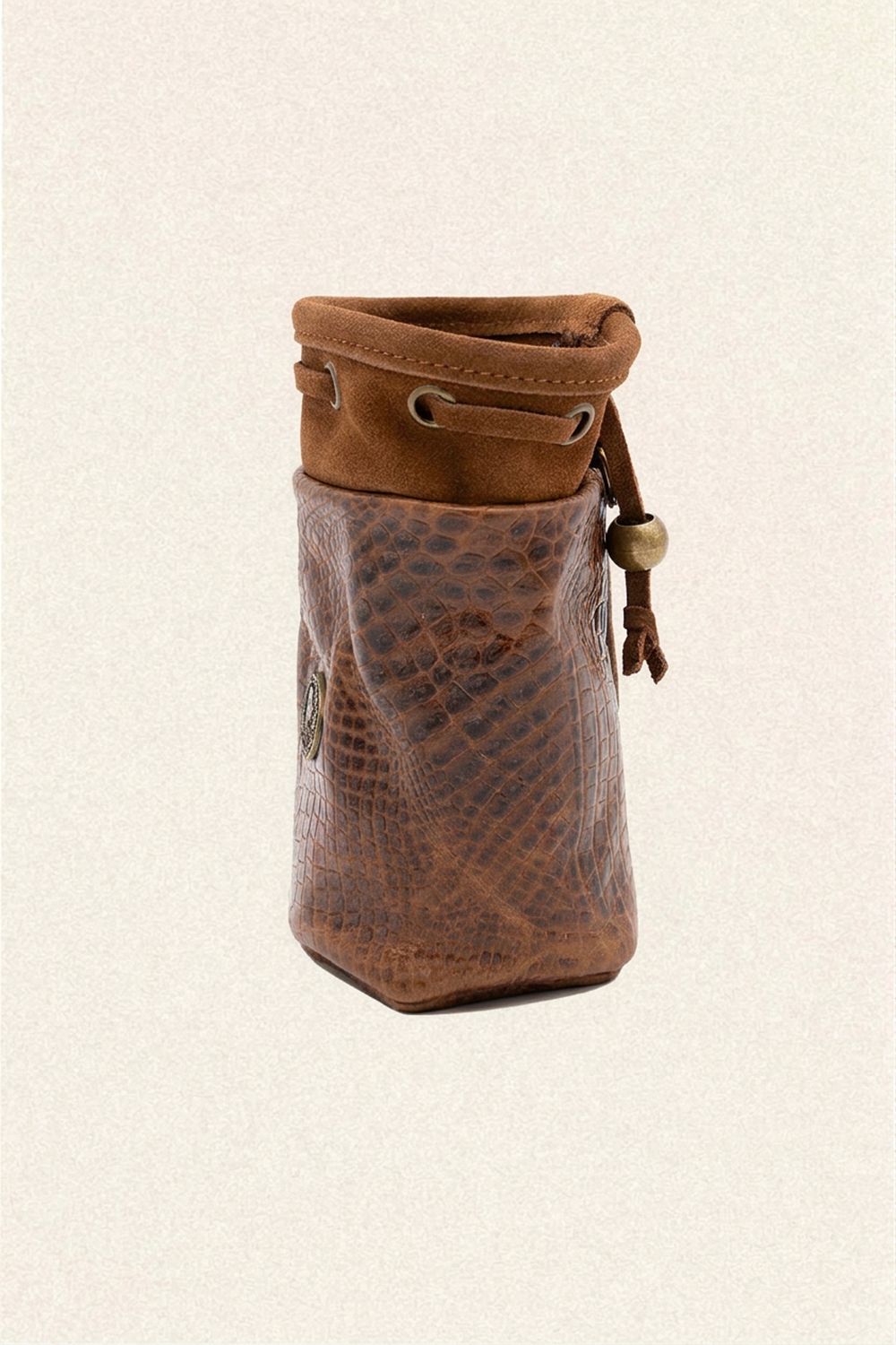 A brown leather pouch with a textured python-patterned front and a suede-like drawstring top, shown on a light beige textured background.