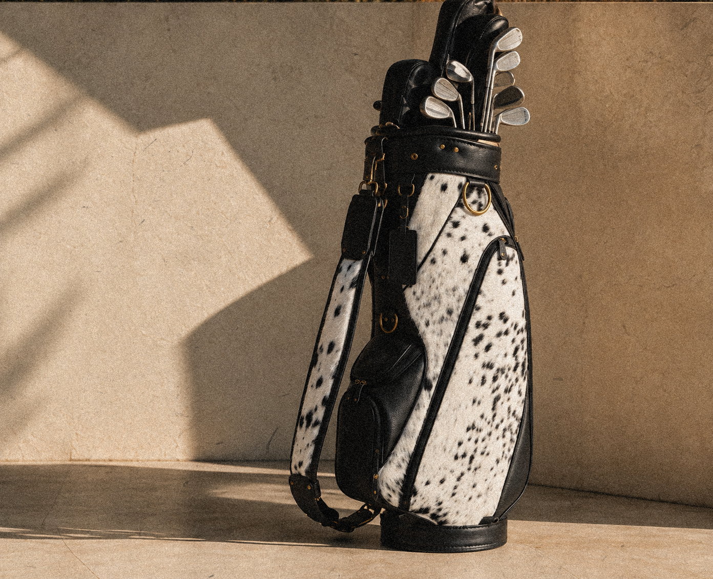 SKINS cowhide golf bag with clubs in warm natural light