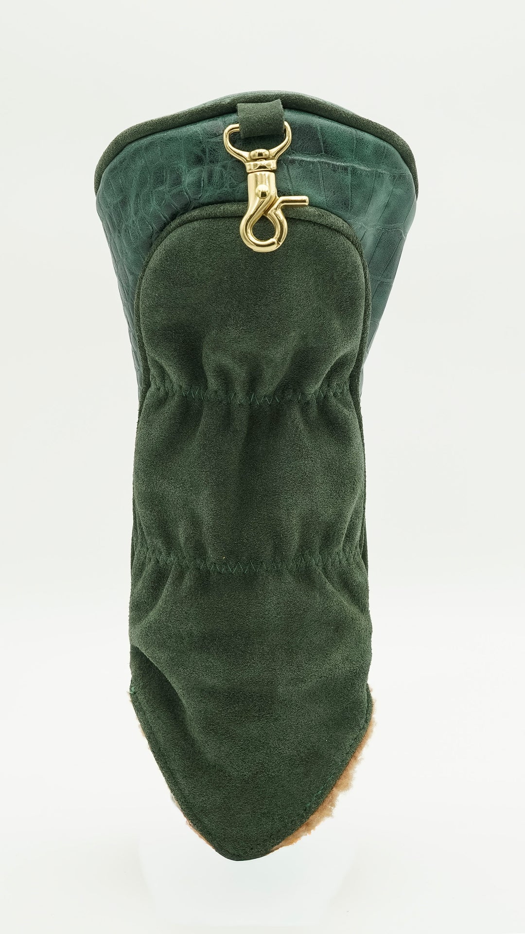 A dark green velvet boot cover with a gold-tone metal clasp, shown on a plain white background.