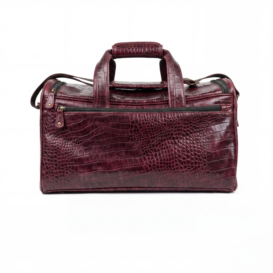 A burgundy crocodile-embossed leather duffel bag with dual top handles and a front zippered pocket, shown against a plain white background.