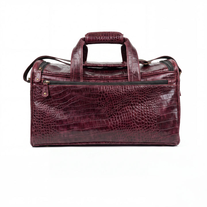 A burgundy crocodile-embossed leather duffel bag with dual top handles and a front zippered pocket, shown against a plain white background.