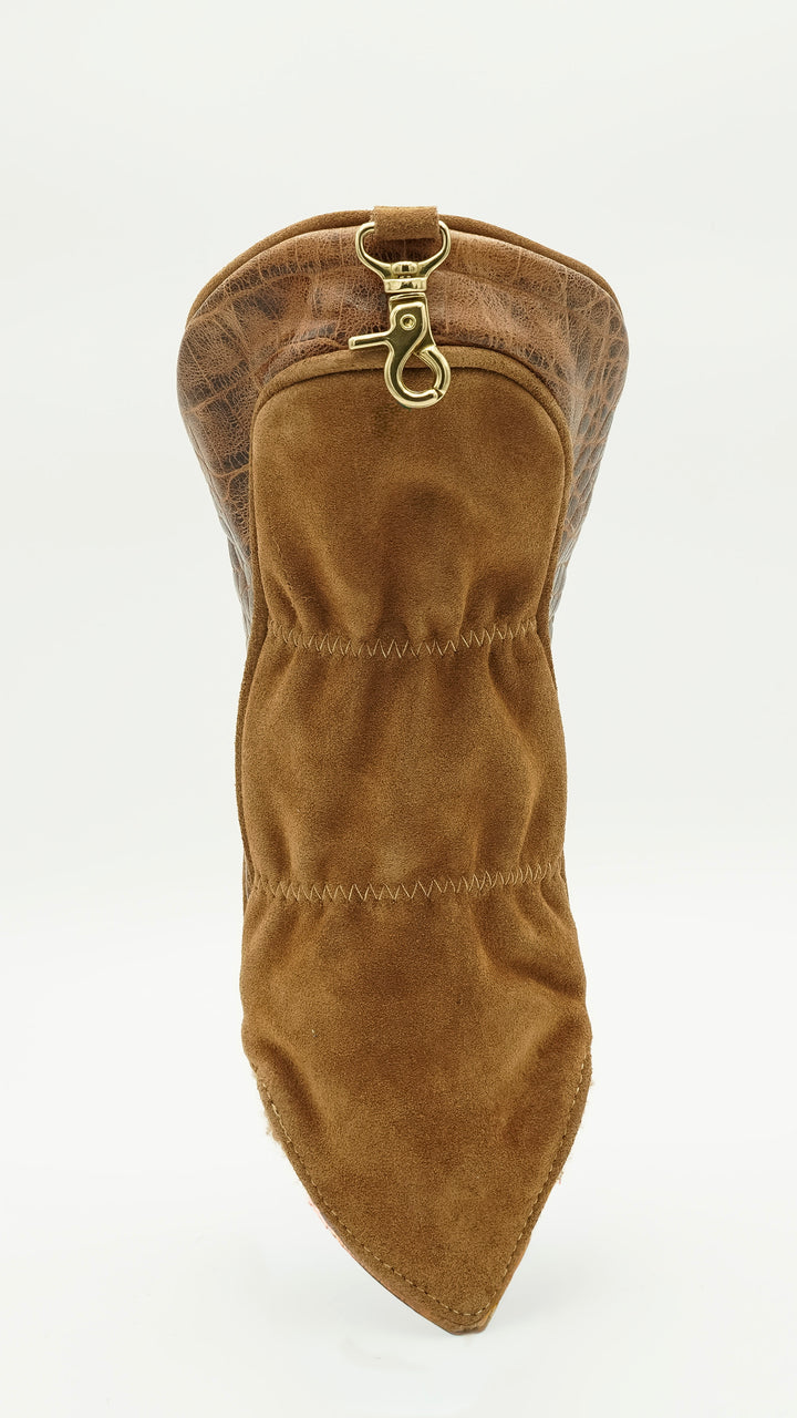 A brown suede boot cover with a pointed toe and a gold-tone metal snap hook closure at the top, shown against a plain white background.